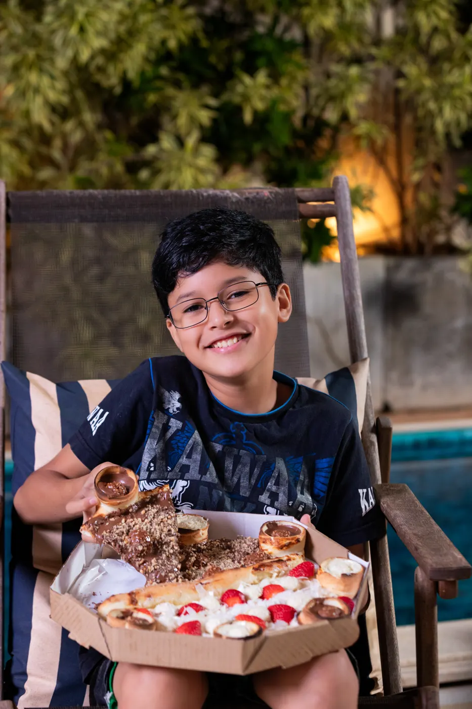 Criança sorrindo com um pedaço de pizza doce com borda vulcão